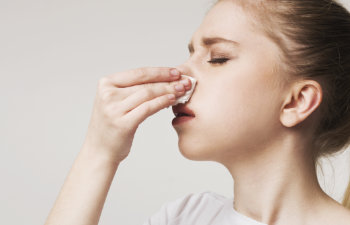 young woman suffering from nose bleeding